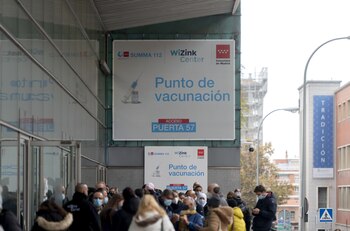 Varias personas hacen cola para