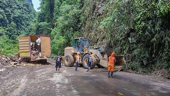 Trabajadores y maquinaria pesada remueven