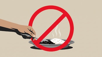Una mano acerca una cuchara a un plato con arroz y frijoles, cubiertos en el centro por una señal roja de prohibición sobre fondo beige.