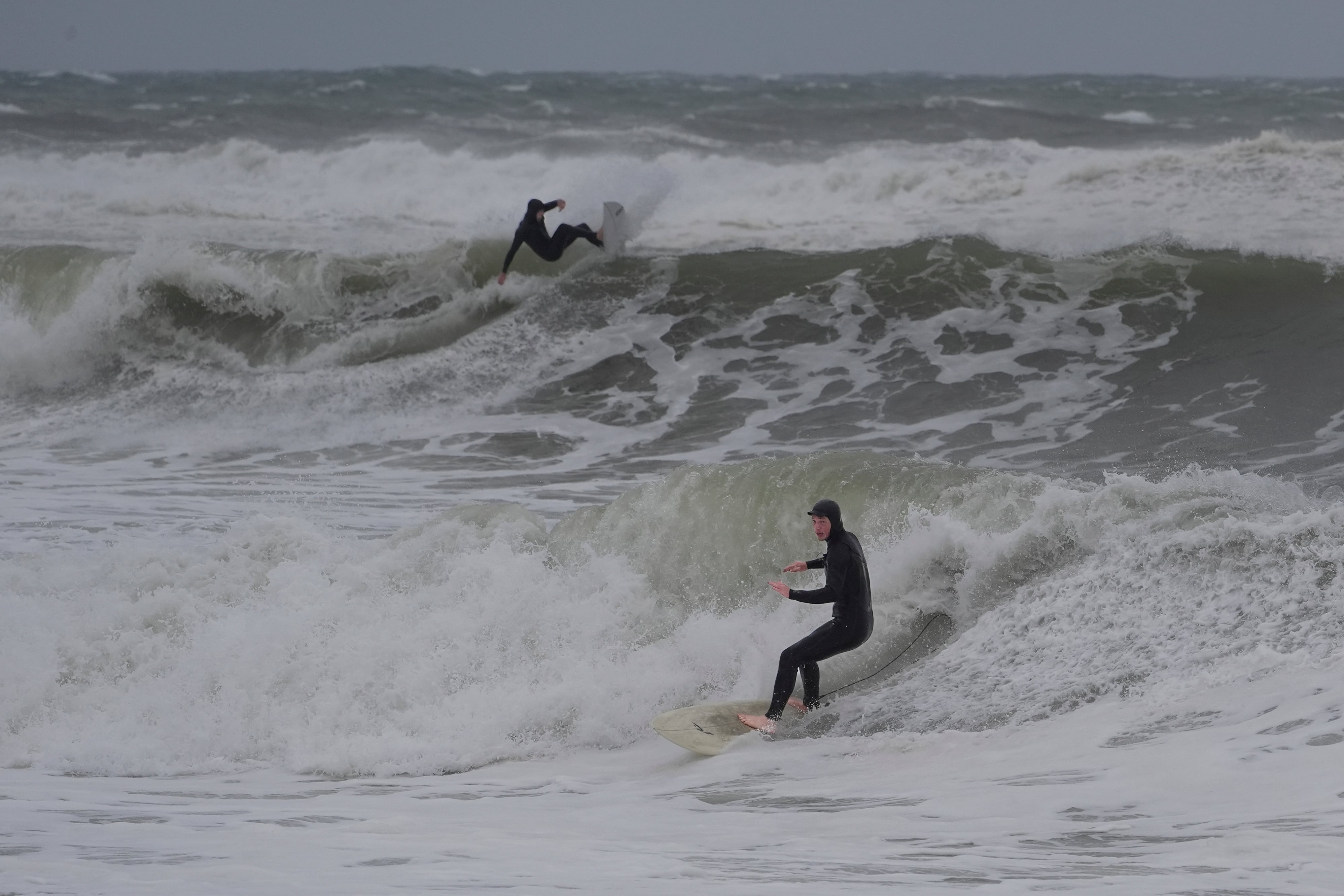 Surfistas surcan las olas provocadas por una tormenta del noreste el sábado 26 de septiembre de 2026 en Hampton, New Hampshire (AP/Robert F. Bukaty)