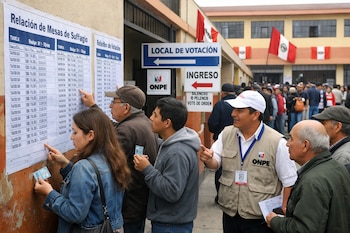 Personas consultan listas de mesas de sufragio en un colegio peruano. Un oficial de la ONPE asiste a votantes. Banderas de Perú visibles al fondo.