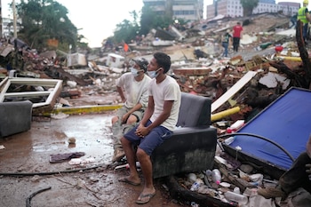 Residentes que ayudan en las labores de rescate se sientan entre escombros que dejaron los terremotos en La Guaira, Venezuela, el 30 de junio de 2026
(Foto AP/Ariana Cubillos)