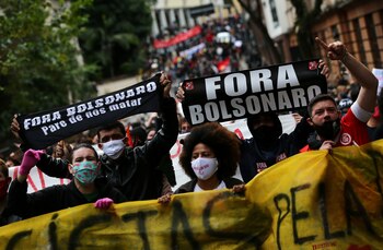 Algunos manifestantes marchan con banderas