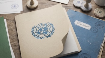 Un informe con el emblema de las Naciones Unidas y una carpeta azul con el texto SSC-CDMX sobre una mesa de madera con sellos oficiales.