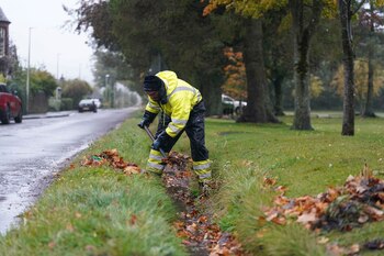Un trabajador limpia una zanja