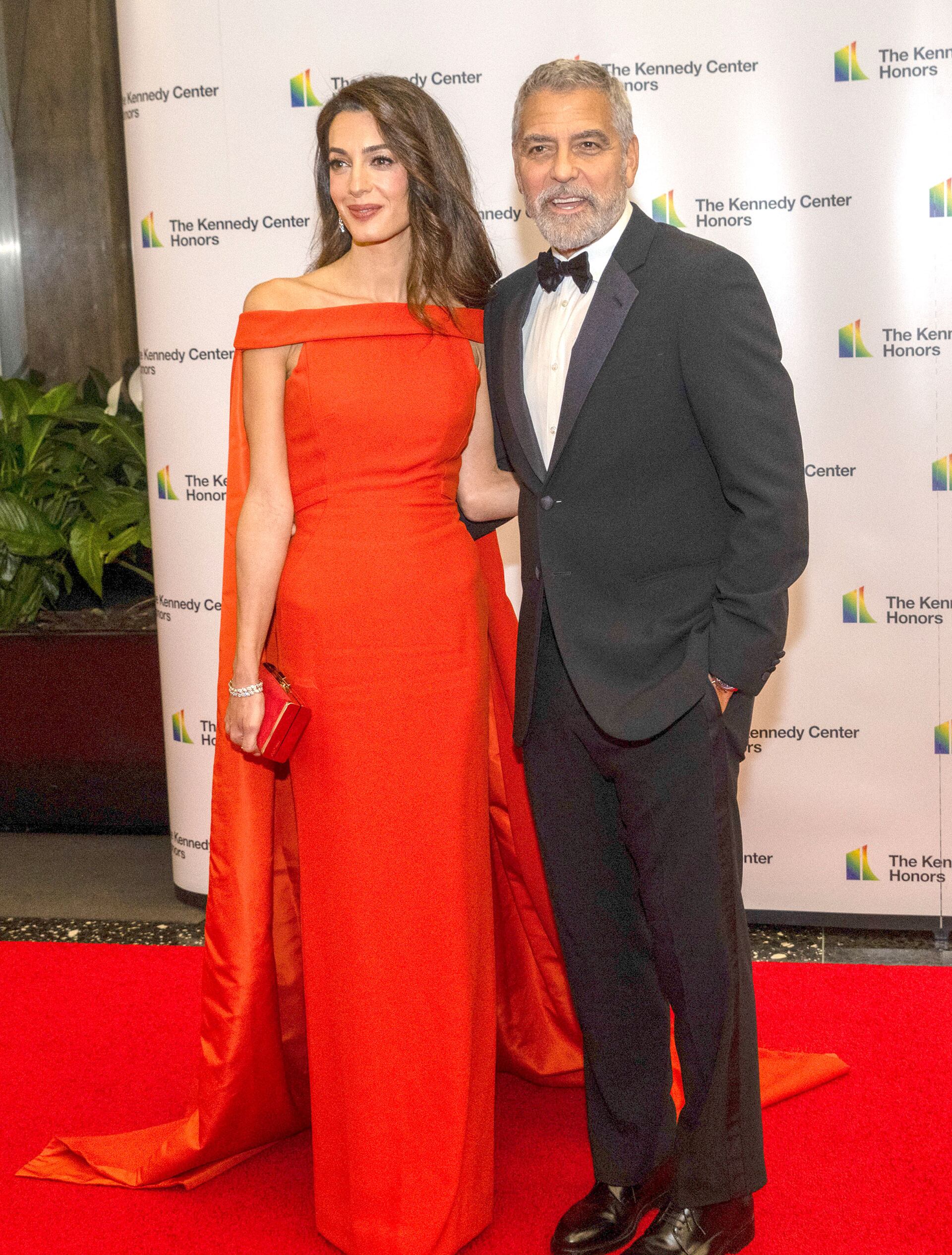 Evento 2022: Amal en rojo con capa y George con esmoquin clásico (The Grosby Group)
