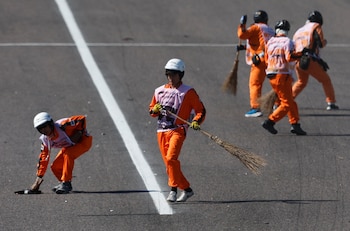 Los marshals también se encargan de limpiar la pista (REUTERS/Issei Kato)