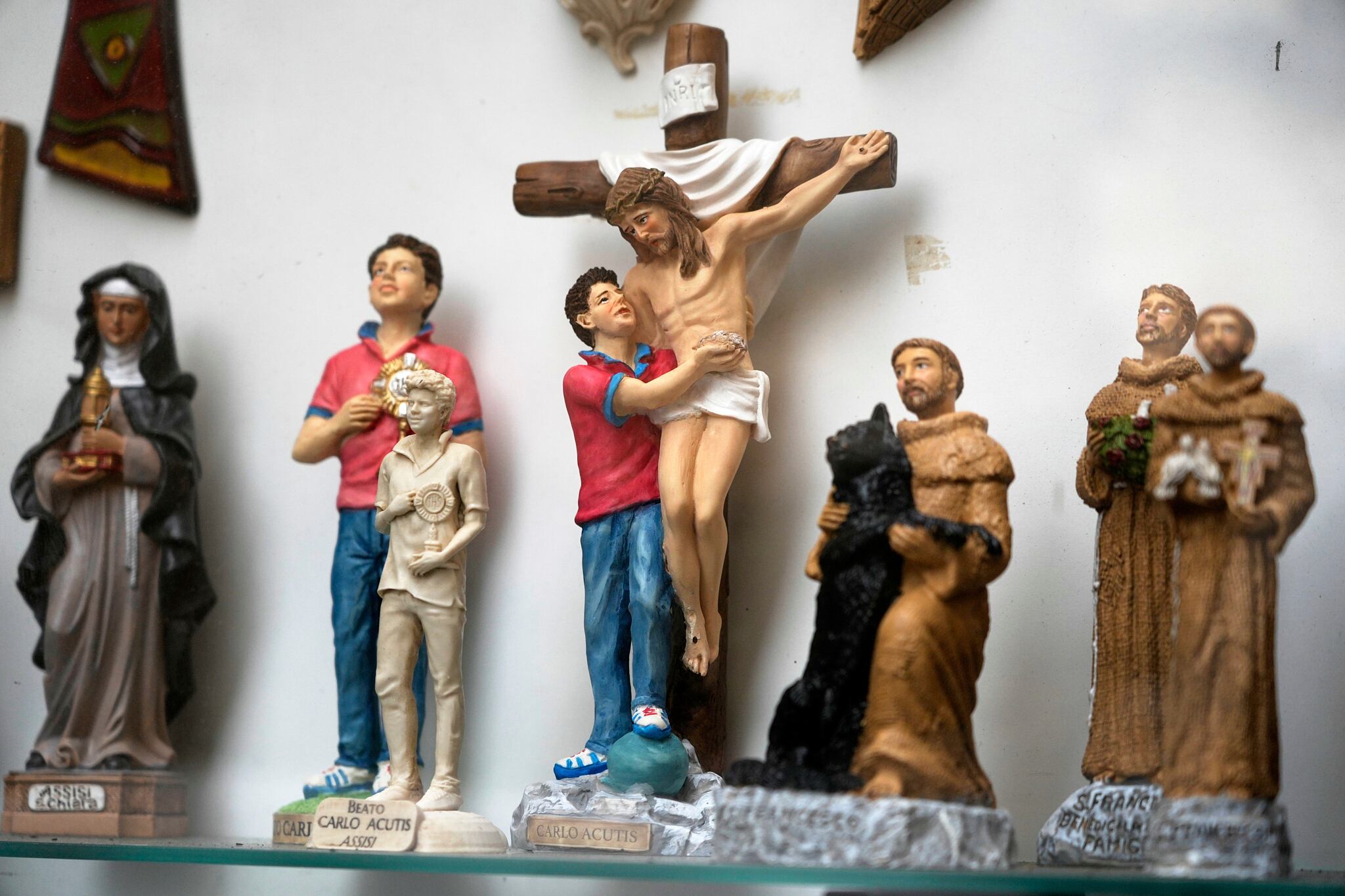 Estatuillas de Carlo Acutis, el adolescente italiano que murió en 2006 de leucemia, se exhiben en una tienda en Asís, Italia, el sábado 1 de marzo de 2025 (AP/Gregorio Borgia)