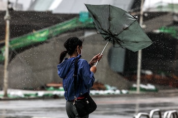 Una joven con su paraguas sufren la lluvia y los vientos en Taiwán (I-Hwa Cheng / AFP)