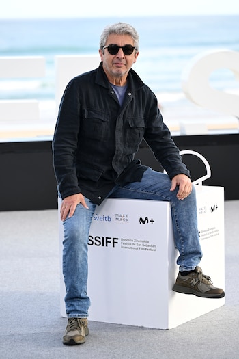 El actor Ricardo Darín, con gafas de sol y chaqueta oscura, posa sentado sobre un cubo blanco promocional del Festival de San Sebastián