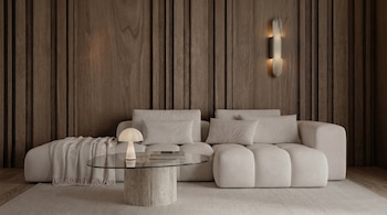 Un salón moderno con un sofá modular beige frente a una pared de madera oscura. Incluye una mesa de centro de cristal, una lámpara, una alfombra y un aplique de mármol.