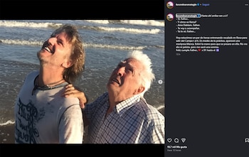 Captura de pantalla de Instagram mostrando a dos hombres en la orilla del mar. El más joven, sonriente, abraza al mayor; ambos miran hacia arriba
