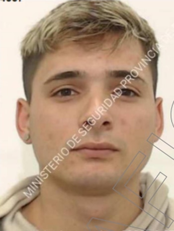 Primer plano del rostro de un hombre joven con cabello rubio claro y corto, ojos oscuros y piel clara, mirando fijo a cámara