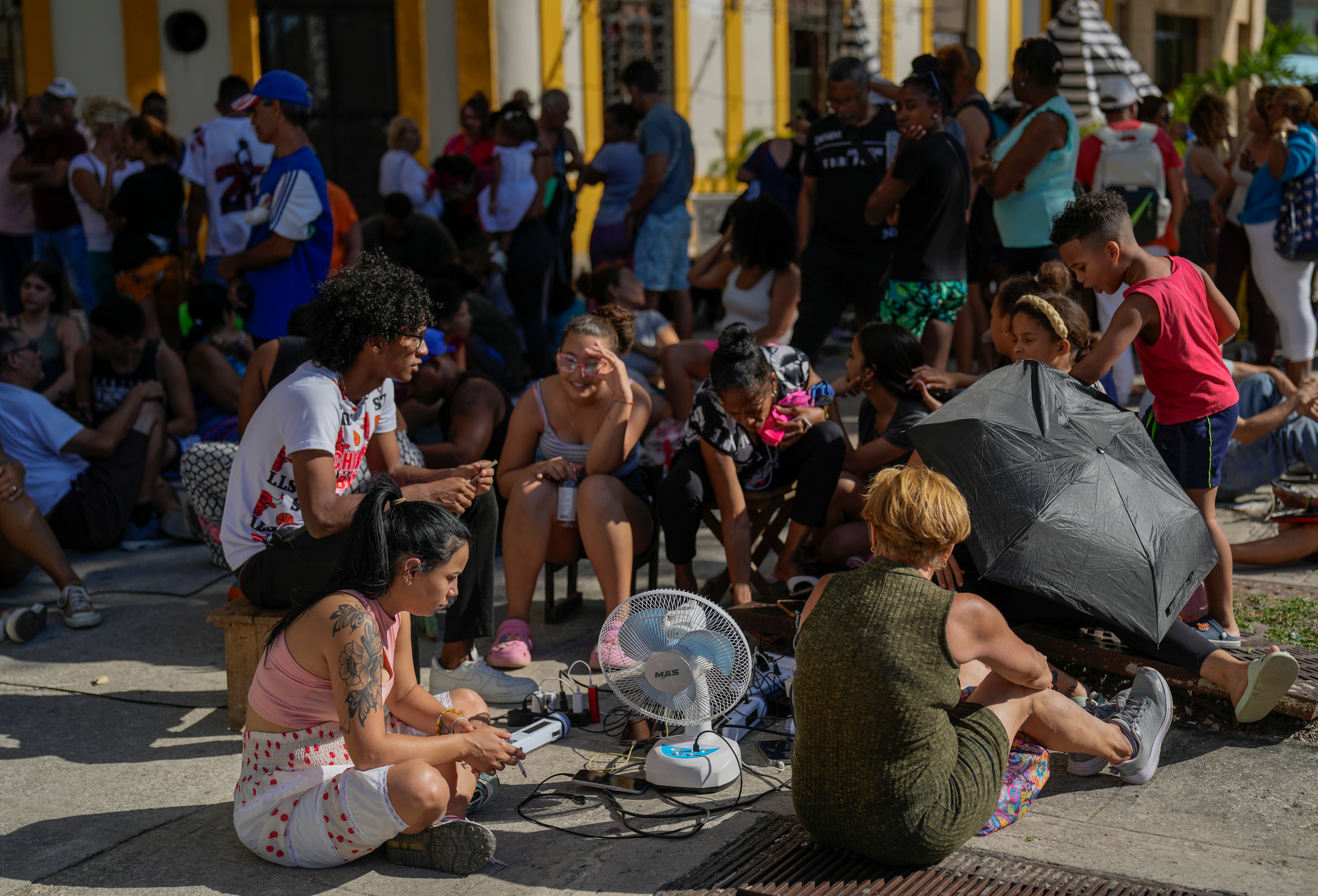 Residentes cargan sus dispositivos electrónicos en la calle durante un apagón nacional en La Habana (AP Foto/Ramón Espinosa/Archivo)