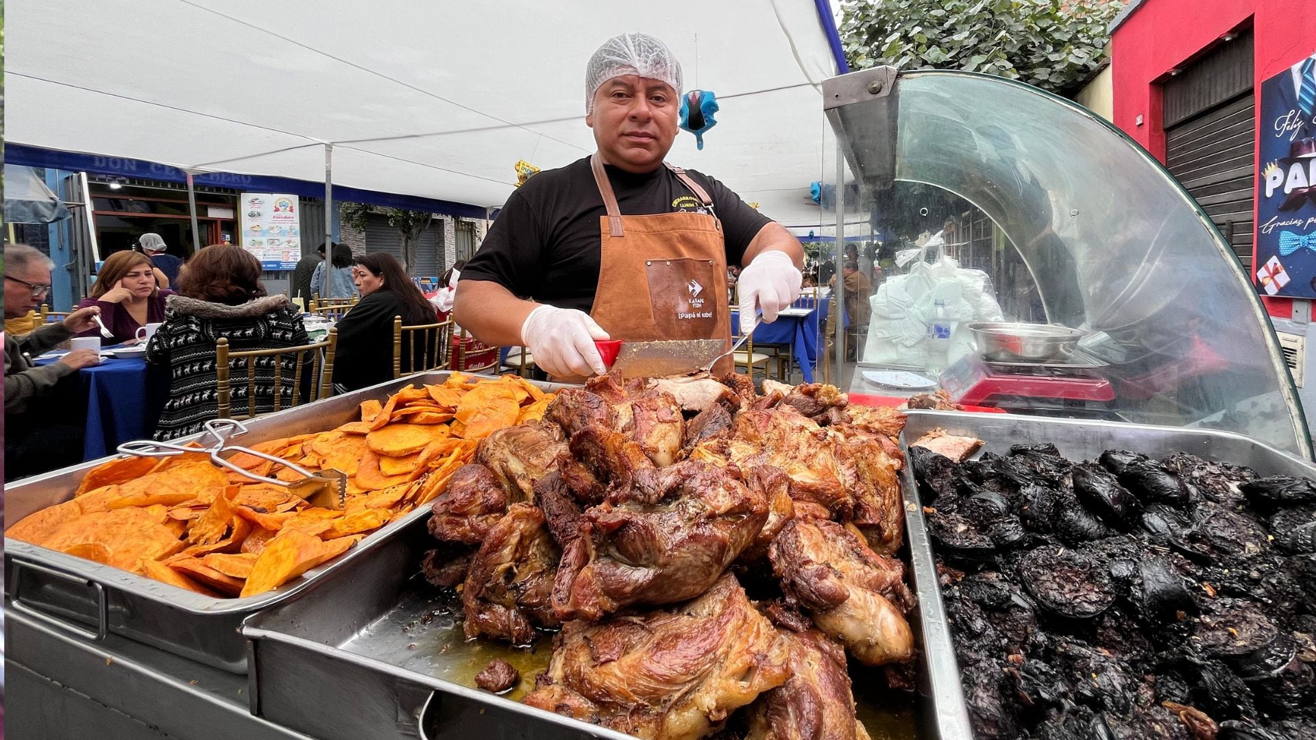 Un cocinero peruano prepara chicharrón y camote frito en un evento culinario, donde los comensales disfrutan de la gastronomía local para celebrar el Día de la Madre. (Municipalidad de Surquillo)