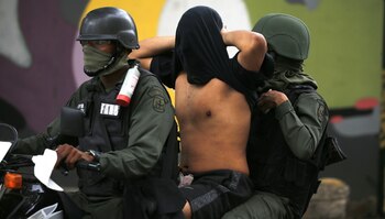 La Guardia Nacional Bolivariana se lleva a una persona detenida en las protestas (AP)