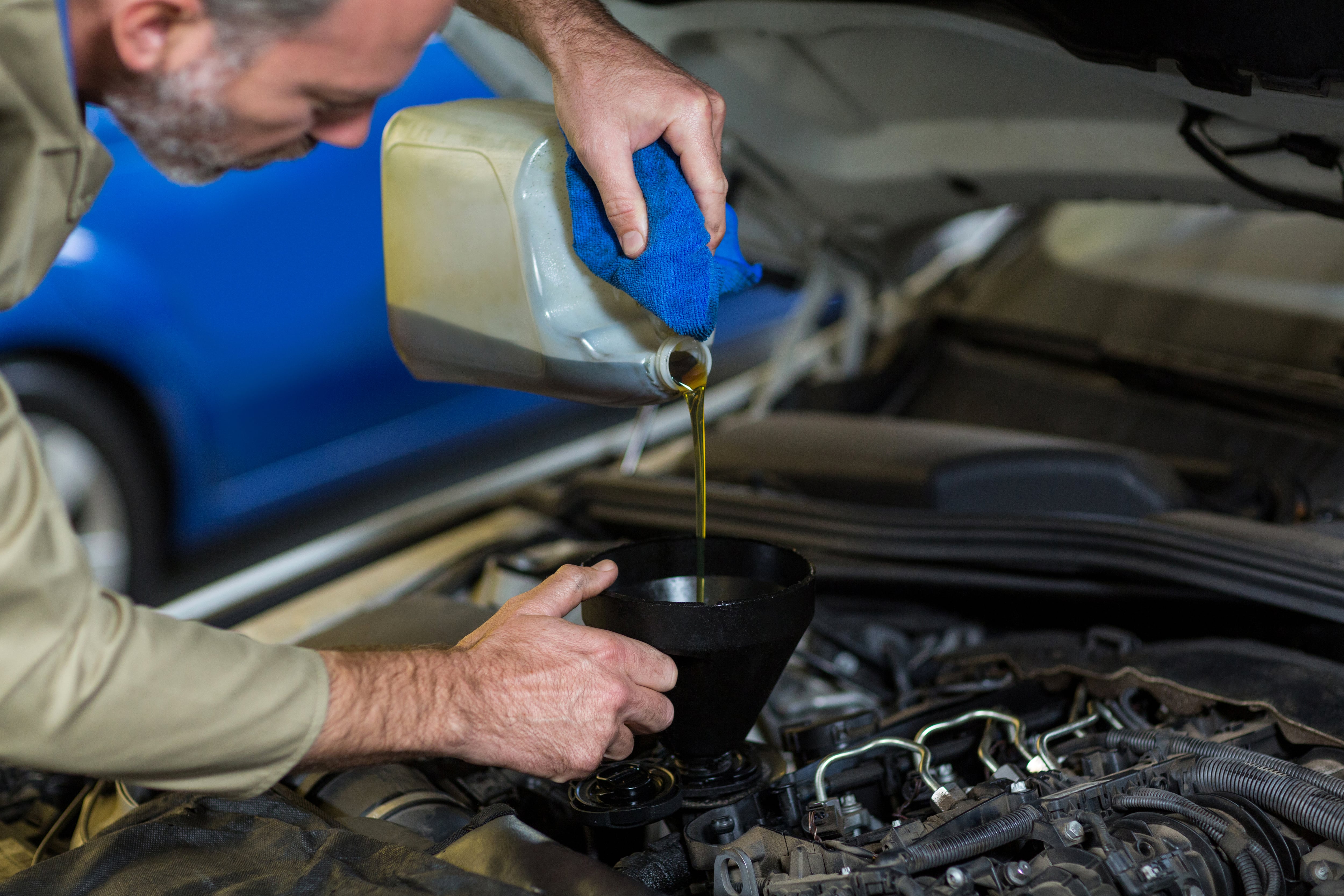 Mecánico cambiando aceite del coche. (Magnific)