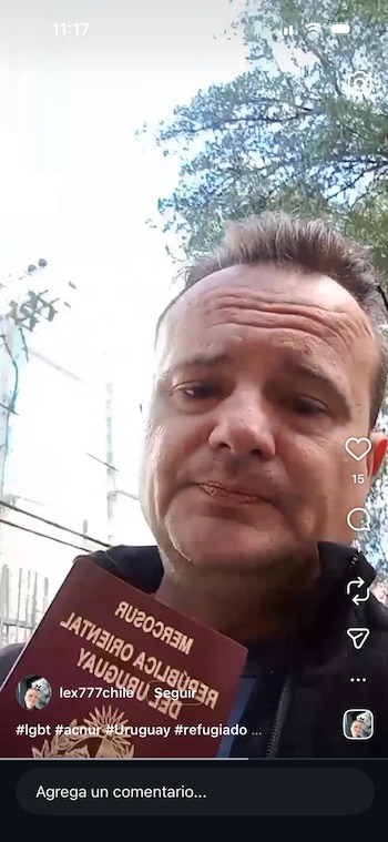 Hombre de mediana edad sostiene pasaporte rojo oscuro de la República Oriental del Uruguay con texto invertido. Fondo exterior borroso con vegetación