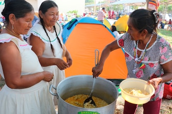 Indígenas bolivianos preparan alimentos en