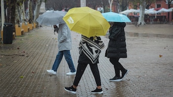 Tres personas se protegen de
