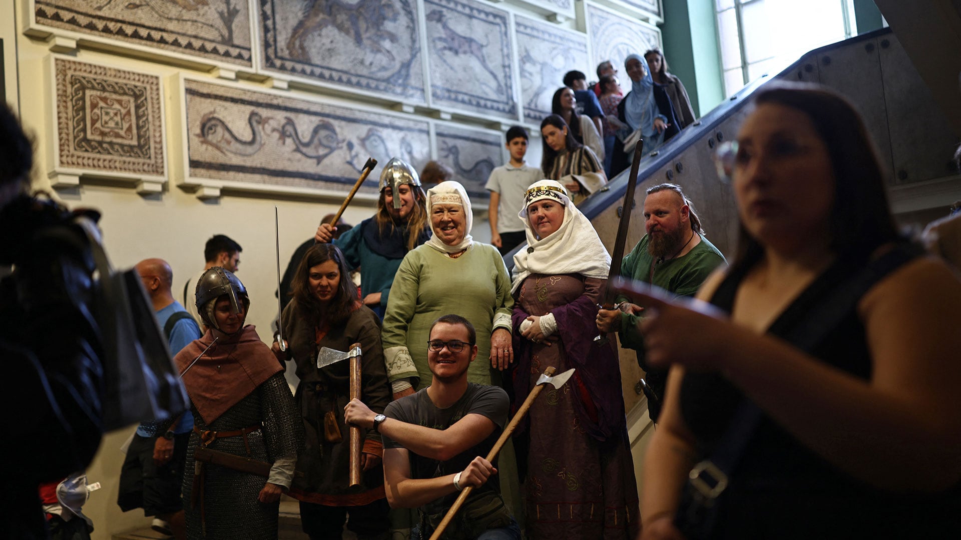 Personal ataviado con trajes de época posa con visitantes en el interior del Museo Británico (Henry NICHOLLS / AFP)