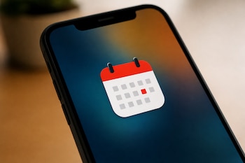 Primer plano de un teléfono móvil con el icono de un calendario blanco y rojo en el centro de la pantalla.