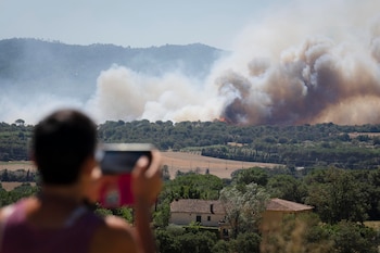 Un hombre observa la columna de humo del incendio forestal que se ha declarado en La Bisbal d'Empordà (Girona). EFE/ David Borrat