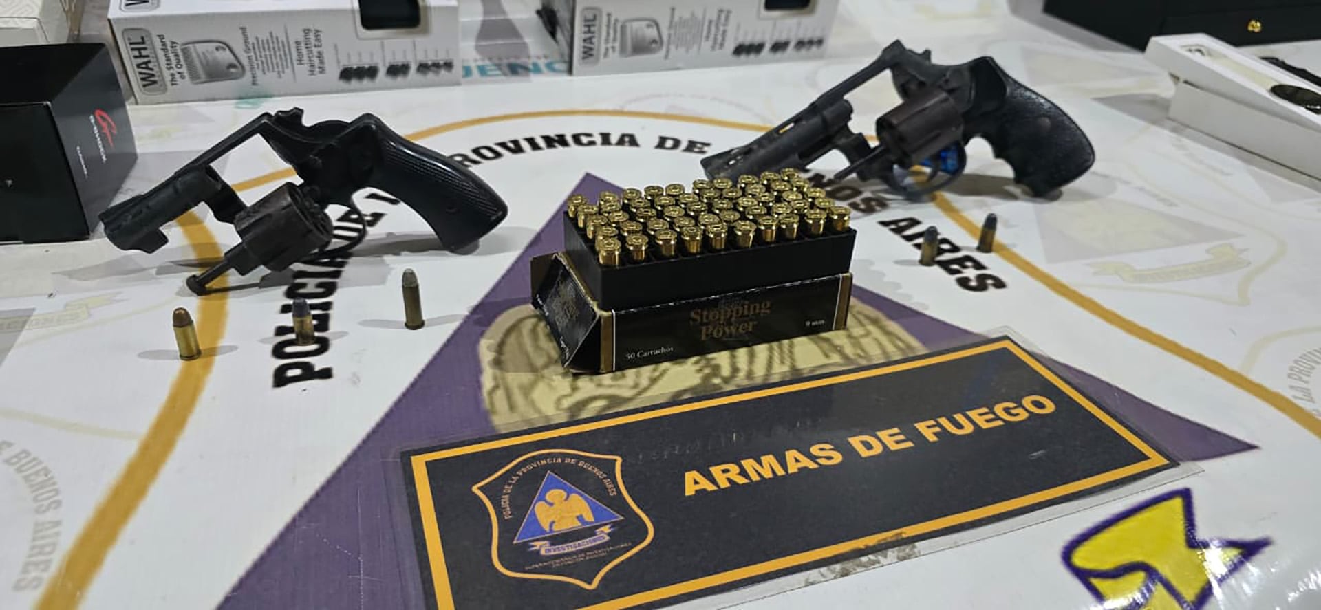En la imagen se muestran dos revólveres, una caja de cartuchos de 9 mm y balas sueltas, parte de un decomiso de armas de fuego por la policía de la Provincia de Buenos Aires.
