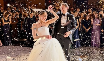 Paula Albarrán y Arturo Elias Slim bailan durante su fiesta de bodas rodeados de confeti y personas invitadas.