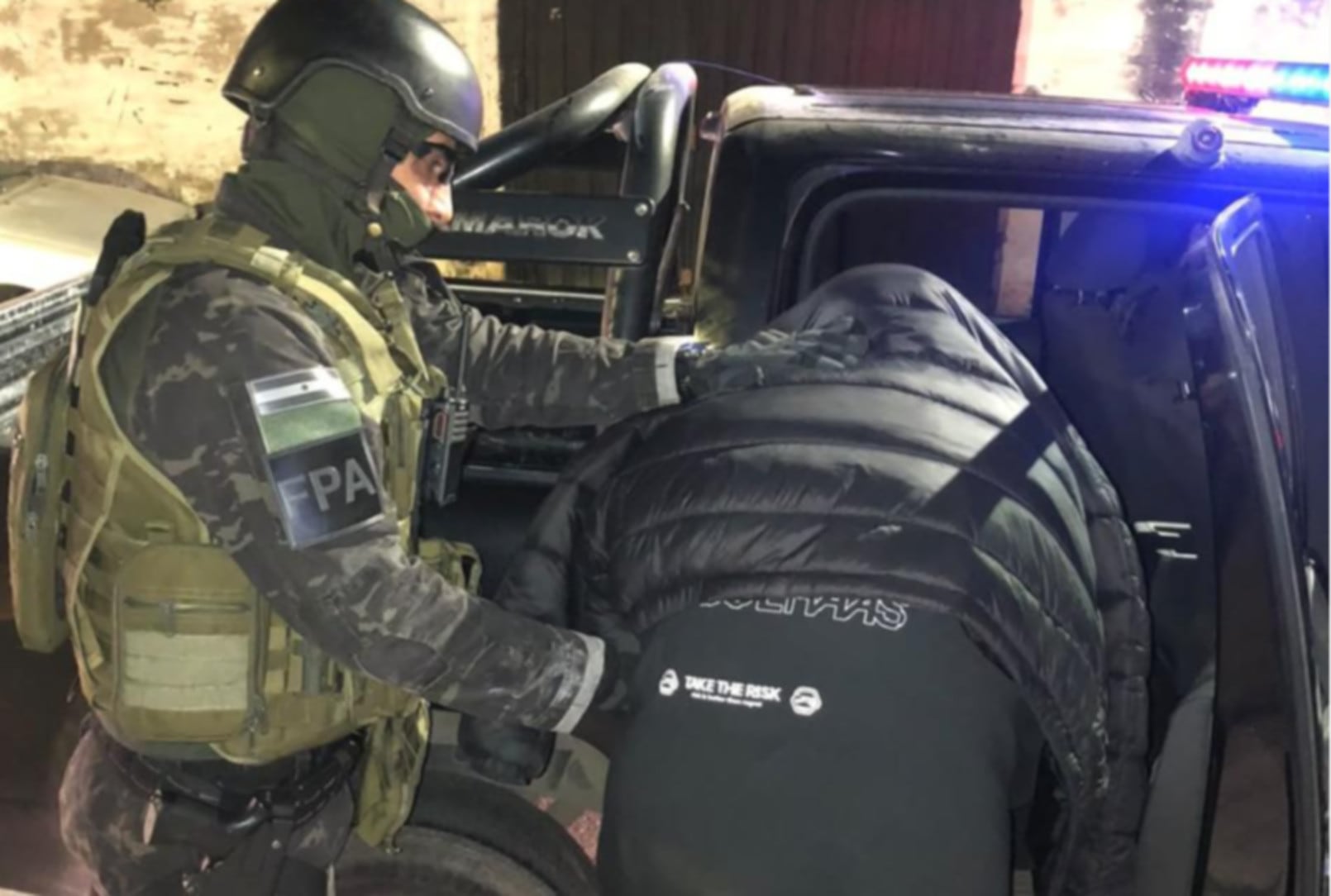 Un oficial de la Fuerza Policial Antinarcotráfico de Córdoba introduce a un detenido en la parte trasera de una camioneta policial durante un operativo para desmantelar puntos de ventas de drogas (Ministerio Público Córdoba)