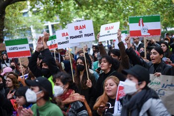 Manifestantes sostienen pancartas contra el