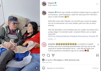 Una mujer y un hombre mayor sentados en un sofá. El hombre viste gorra y gafas. La mujer sostiene una prenda color beige. El hombre sostiene prendas azules y un envoltorio