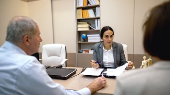 Asesor financiero con clientes de la tercera edad en una oficina (GettyImages)