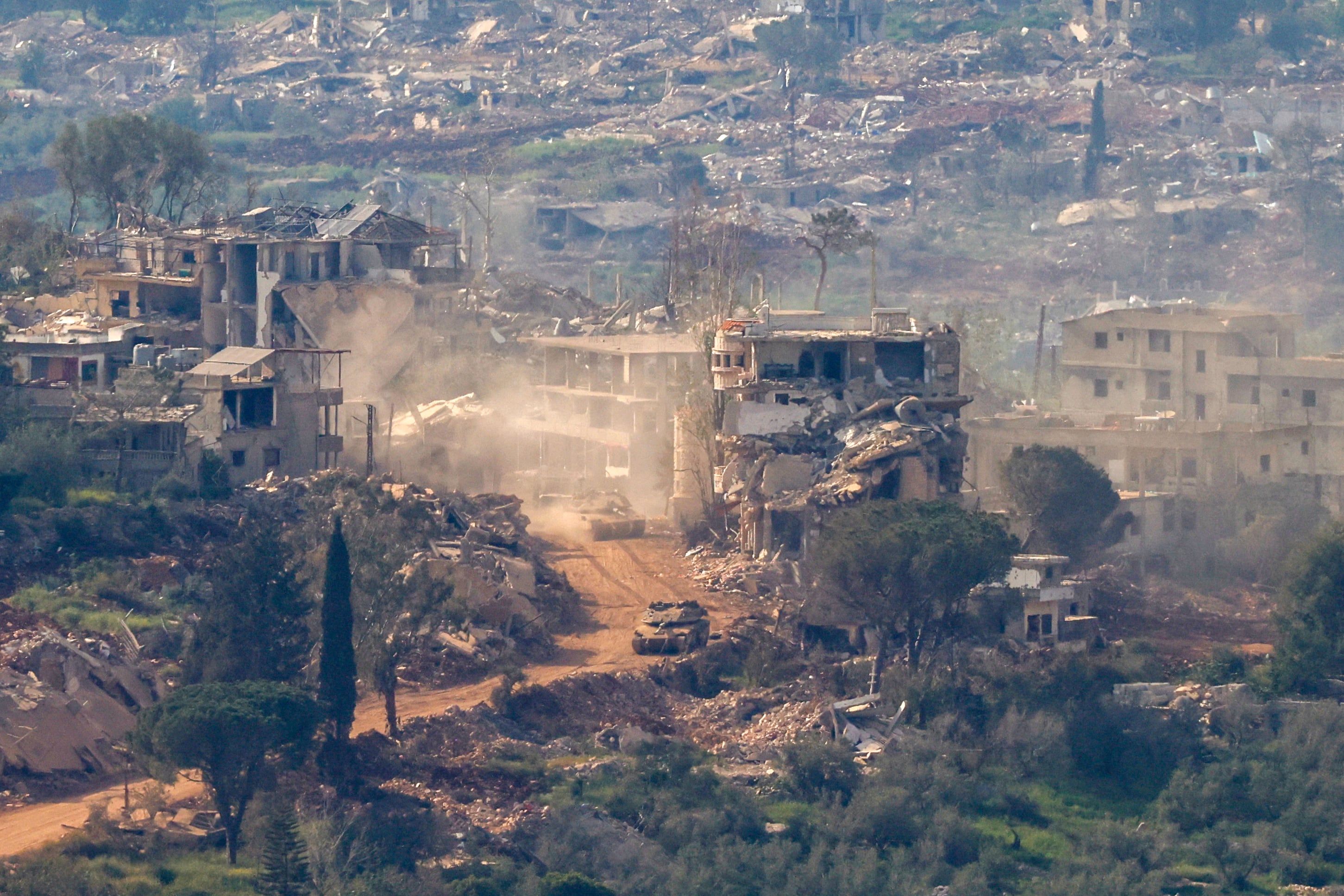 Tanques de Israel avanzan entre ruinas en el sur del Líbano. Netanyahu ordenó hoy atacar con contundencia a Hezbollah tras denunciar violaciones a la tregua vigente. (Jalaa MAREY / AFP)