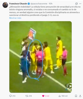 Vista aérea de jugadores de fútbol en uniformes amarillos y un árbitro con camiseta rosa en un campo verde, con un círculo azul marcando un grupo