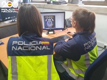 Dos agentes de la Unidad de Atención a la Familia y la Mujer (UFAM) de la Policía Nacional, de espaldas (Policía Nacional)