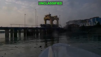Tres fotogramas monocromáticos de un dron marino con estela en el agua, cerca de una costa con edificios. Círculos rojos sobre el dron. Texto 'UNCLASSIFIED'