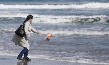 Una mujer arroja flores al