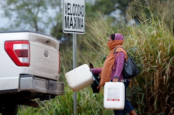 Una mujer lleva contenedores de