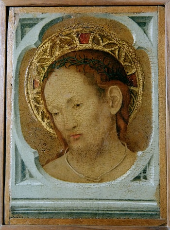 Primer plano de una pintura en tabla con marco de madera. Muestra el busto de Jesús con piel agrietada, barba rala, corona de espinas y un nimbo dorado