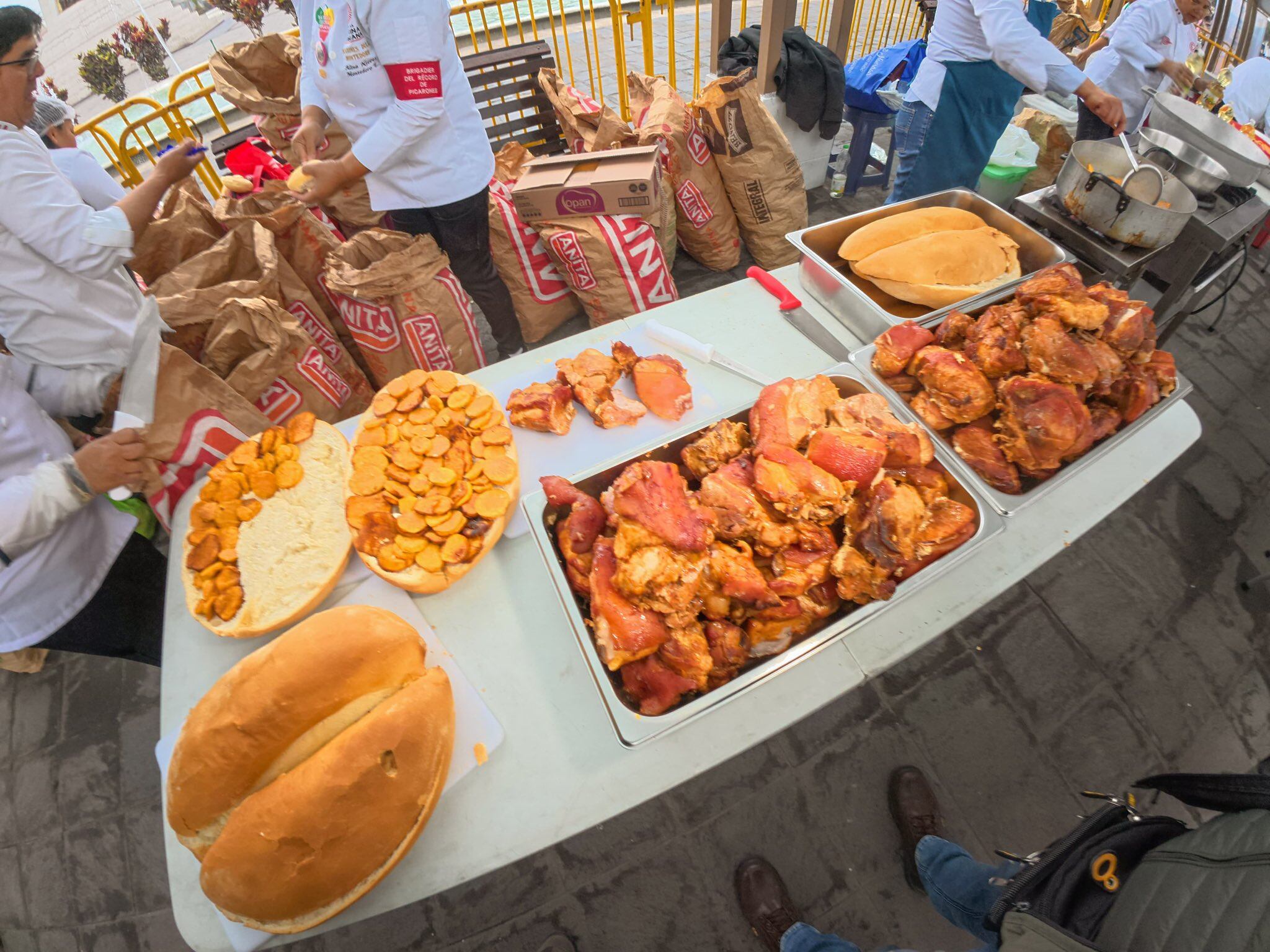El público celebra con entusiasmo la degustación gratuita de cinco mil panes con chicharrón en La Victoria.