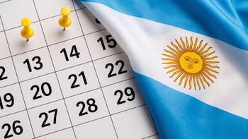 Hoja de calendario con dos chinches amarillas junto a la bandera de Argentina.