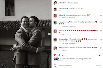 Fotografía en blanco y negro de Bruno Ascenzo y Adrián Bello abrazándose y sonriendo, ambos vestidos con traje, frente a una edificación antigua