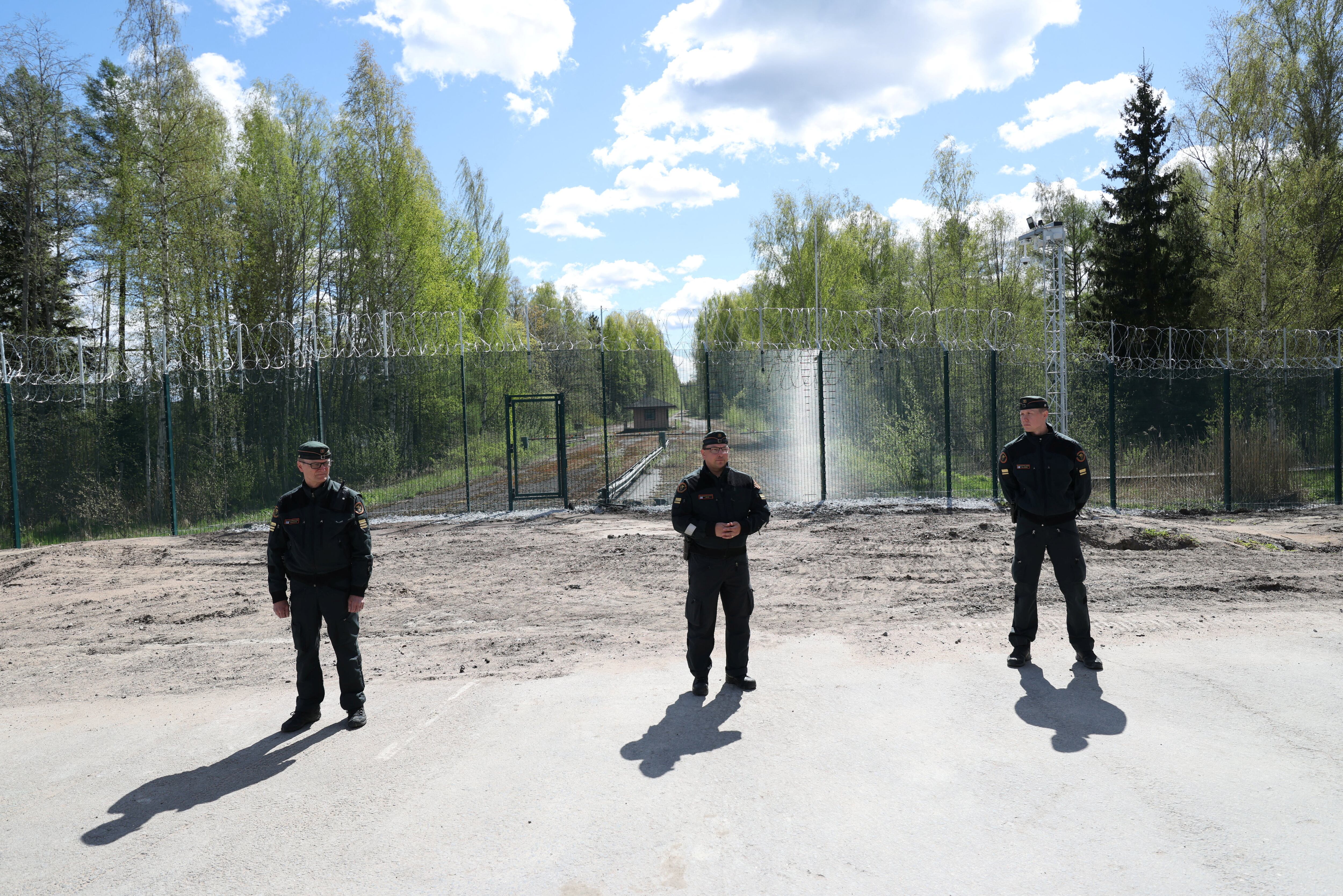 El Jefe de Operaciones del Distrito de la Guardia Fronteriza del Sureste de Finlandia, mayor Samuel Siljanen, el Comandante Adjunto, mayor Antti Virta, y el especialista en vallas de barrera (no en servicio permanente) Esa Veikkanen, junto a la nueva valla de barrera en la frontera entre Finlandia y Rusia en Nuijamaa, Finlandia (REUTERS/Leonhard Foeger)
