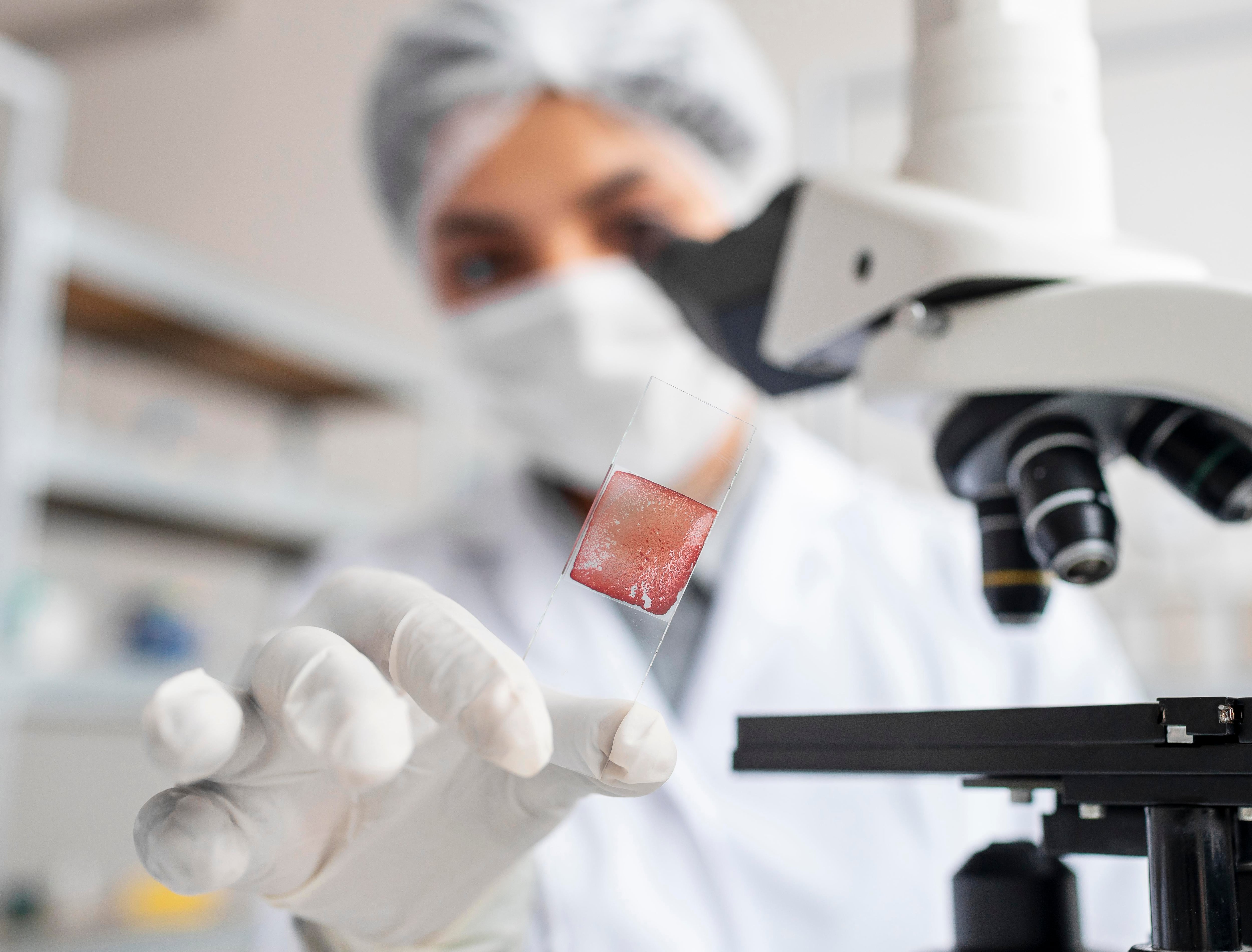 Una científica investiga en un laboratorio con una muestra de células (Magnific)