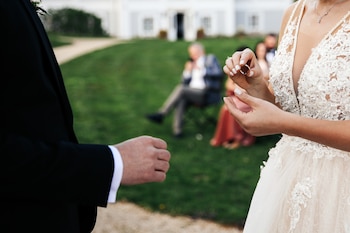 Una pareja de novios intercambiando los anillos el día de su boda (Magnific)