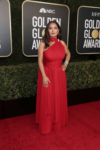 La actriz mexicana Salma Hayek lució un vestido color rojo de cuello halter con falda de diseño en cascada. Completó el look con anillos, brazaletes y de diamantes de Harry Winston