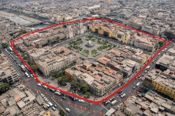 Vista aérea del Centro Histórico de Lima, edificios, plazas, río Rímac, un puente, líneas rojas, conos naranjas, autos detenidos, patrullas.