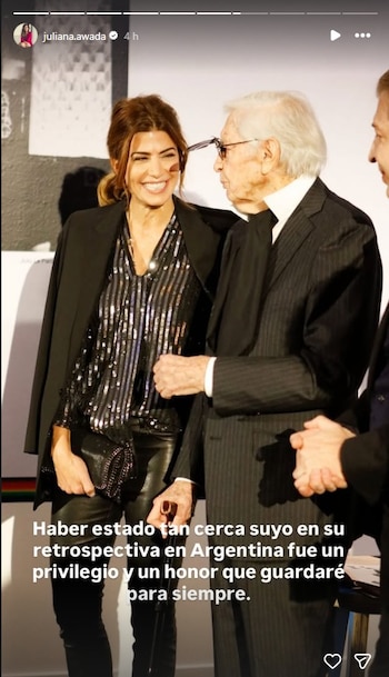 Juliana Awada, vestida con blusa de lentejuelas y blazer, sonríe mirando a Julio Le Parc, quien lleva traje y gafas