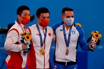 Los chinos Liu Yang (c-oro) y Hao You (i-plata) y el griego Eleftherios Petrounias (d-bronce) celebran en el podio tras la final de anillas masculino de Gimnasia Artística durante los Juegos Olímpicos 2020, este lunes en el Centro de Gimnasia de Ariake de Tokio (Japón). EFE/ José Méndez